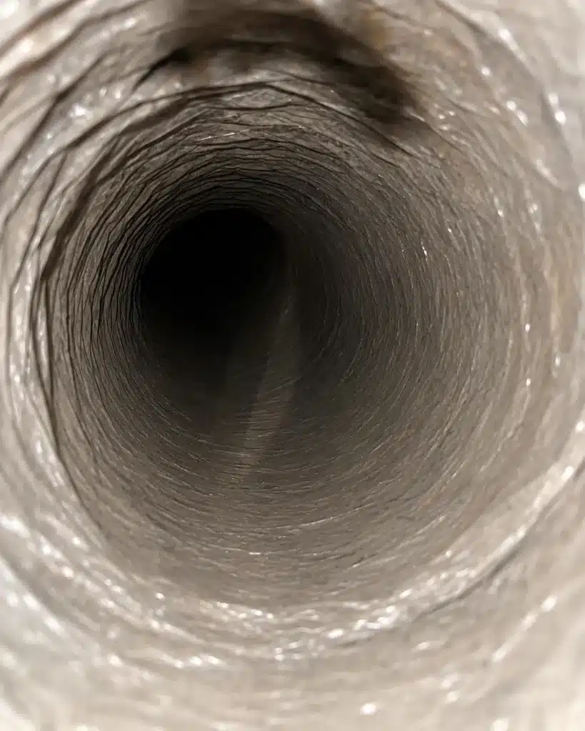 Air duct cleaning: inside a flexible duct run showing a clean, light-colored inner liner