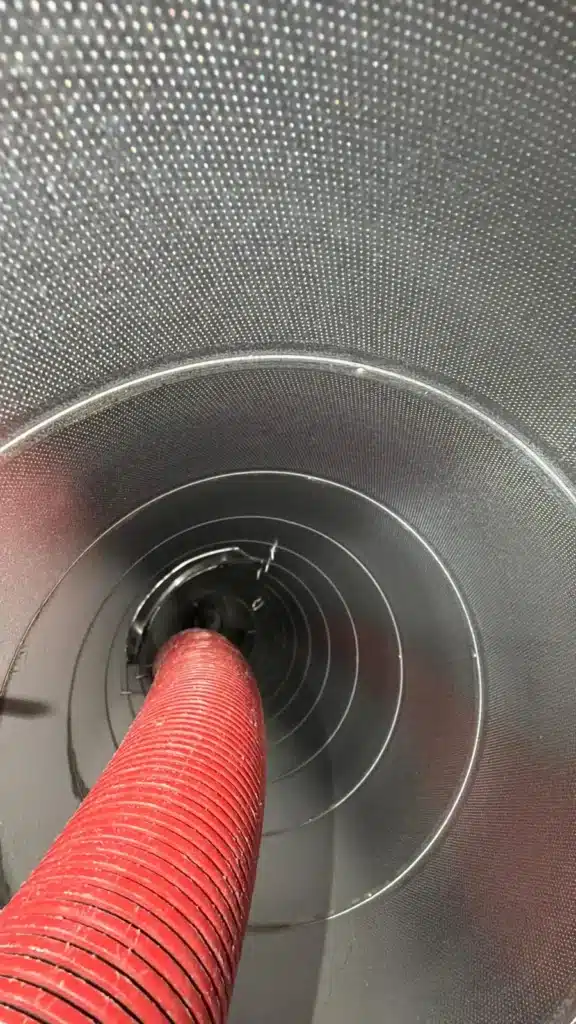 Air duct cleaning: cleaning hose inserted into a metal duct line during service