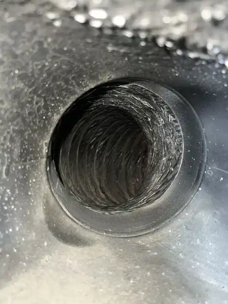 Air duct cleaning: view into a flex duct line through a round metal register boot