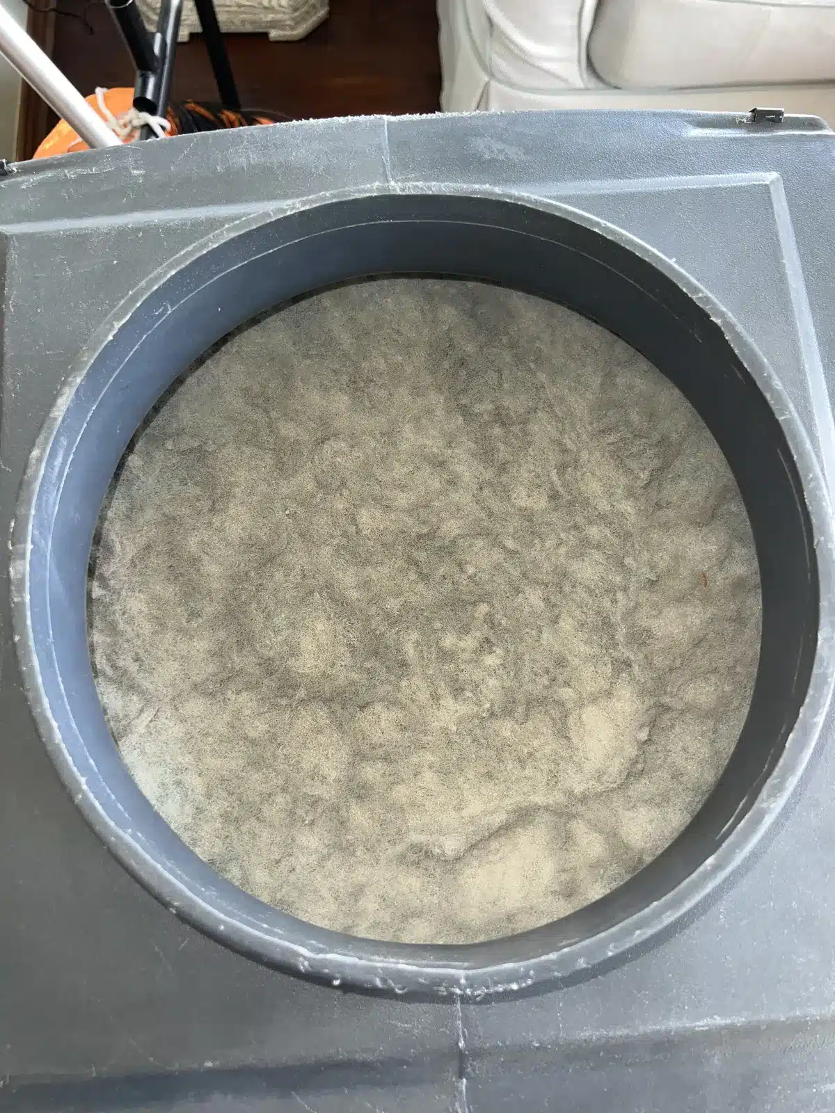 Air duct cleaning close-up: blue filter media inside the collector with orange flex duct attached on top