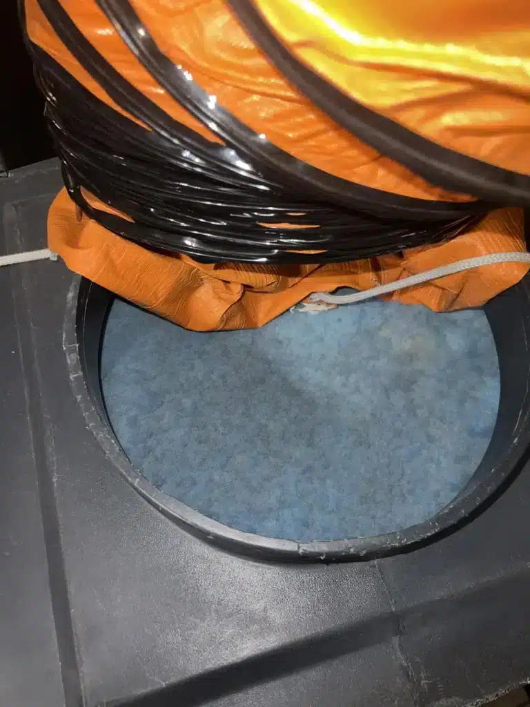 Air duct cleaning in a kitchen: flex duct seals the ceiling return to a negative air machine below