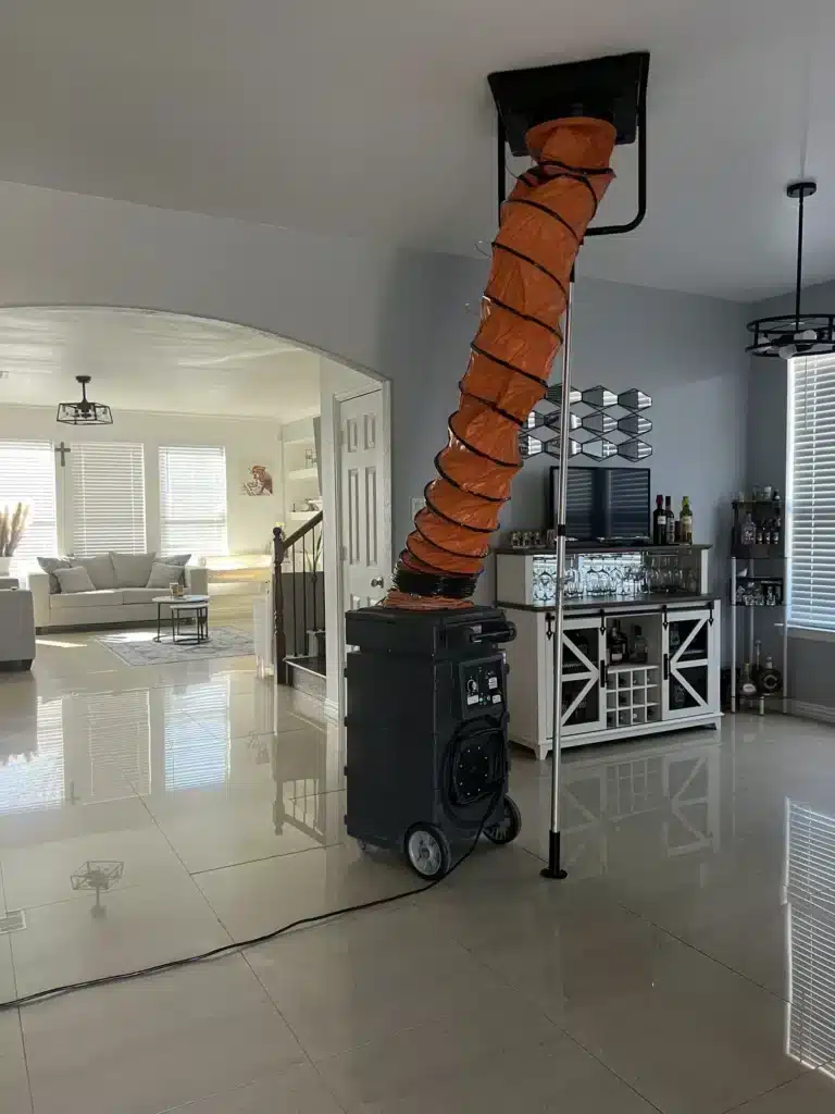 Air duct cleaning: negative air machine ducted to a ceiling return vent in a tiled living area