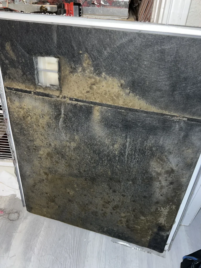 Air duct sanitizing: large filter panel blackened with dust and mildew-like buildup before service
