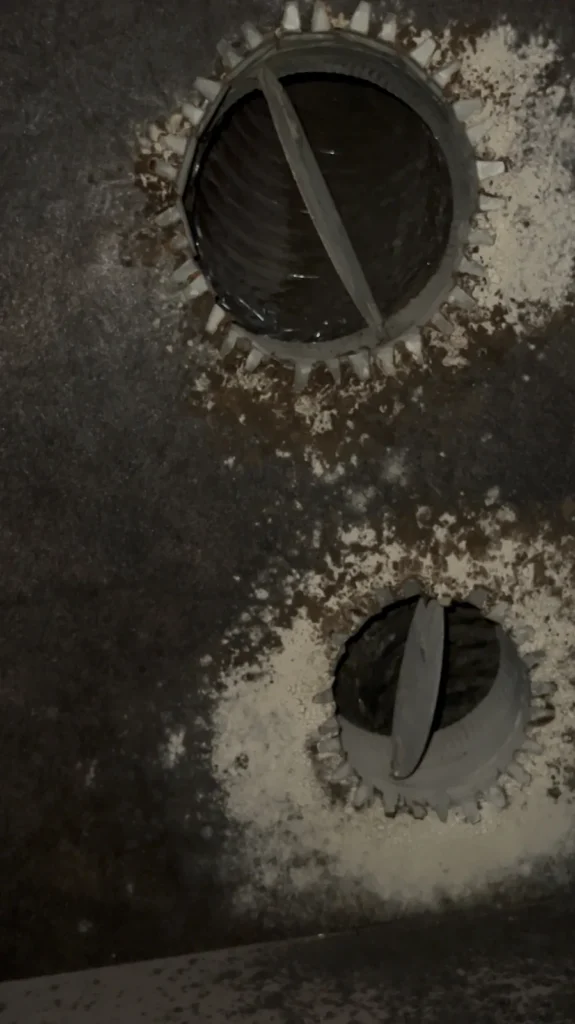Air duct sanitizing: two duct collars inside a plenum showing heavy dust before treatment