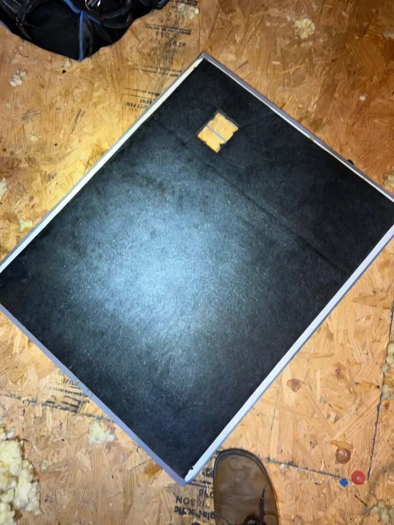 Air duct sanitizing prep: duct board panel removed and set on the attic decking for inspection