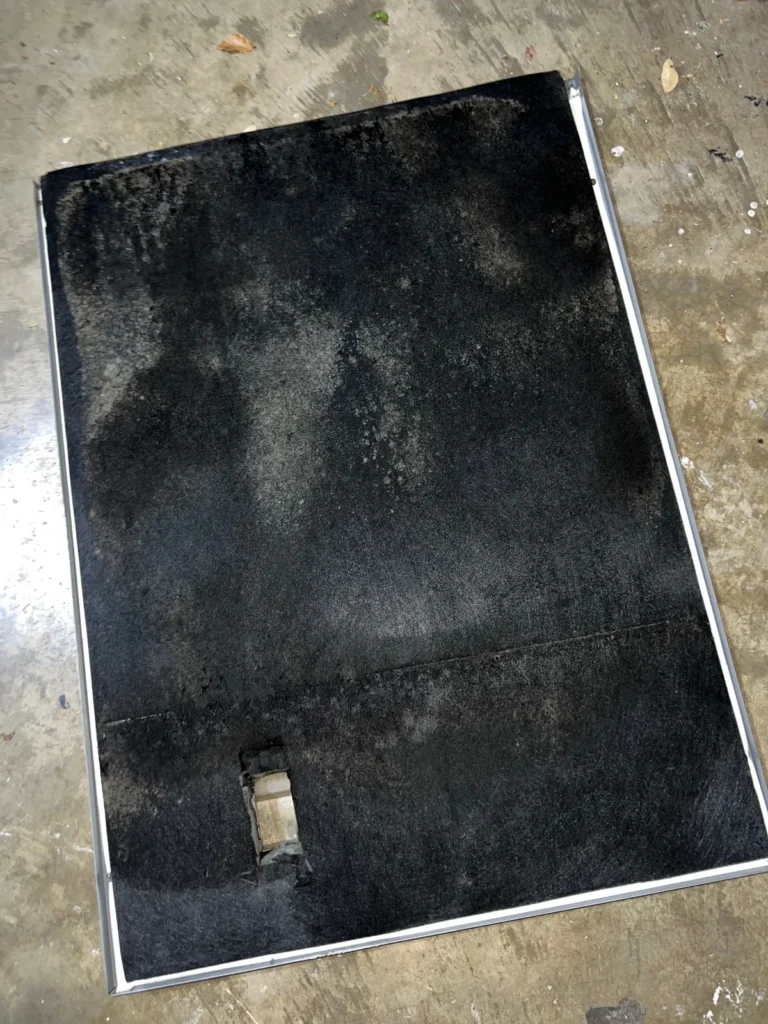 Air duct sanitizing: removed duct panel showing widespread dark contamination across the liner