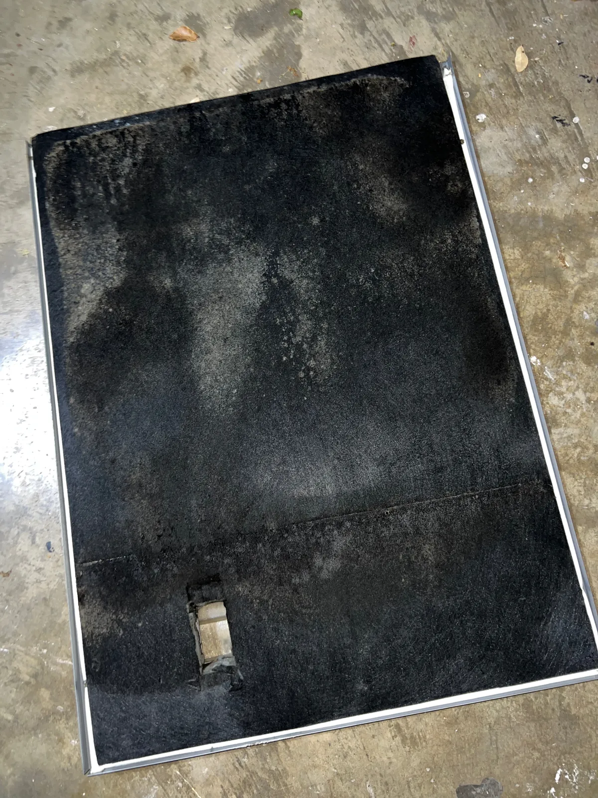 Air duct sanitizing: removed duct panel showing widespread dark contamination across the liner
