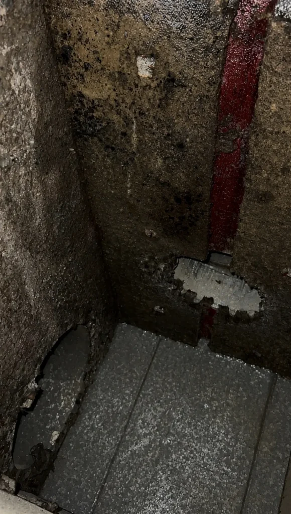Grimy duct interior walls contrasted with a section cleaned down to fresh insulation