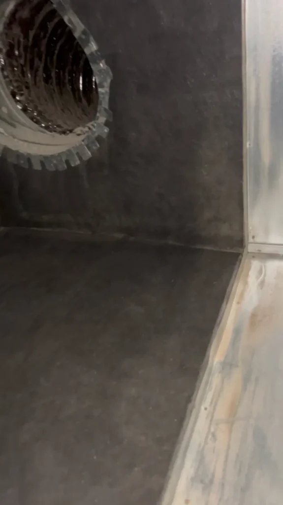 Sheet metal plenum interior wiped clean, duct collar visible in the corner