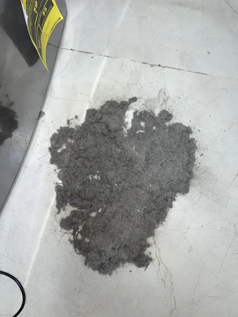 Dryer vent cleaning: mound of lint collected on top of the dryer after clearing the line