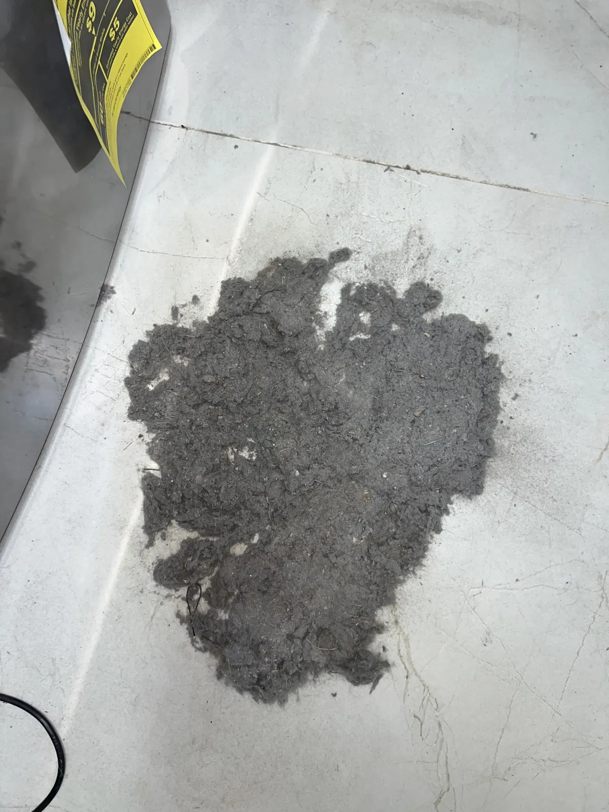 Dryer vent cleaning: mound of lint collected on top of the dryer after clearing the line