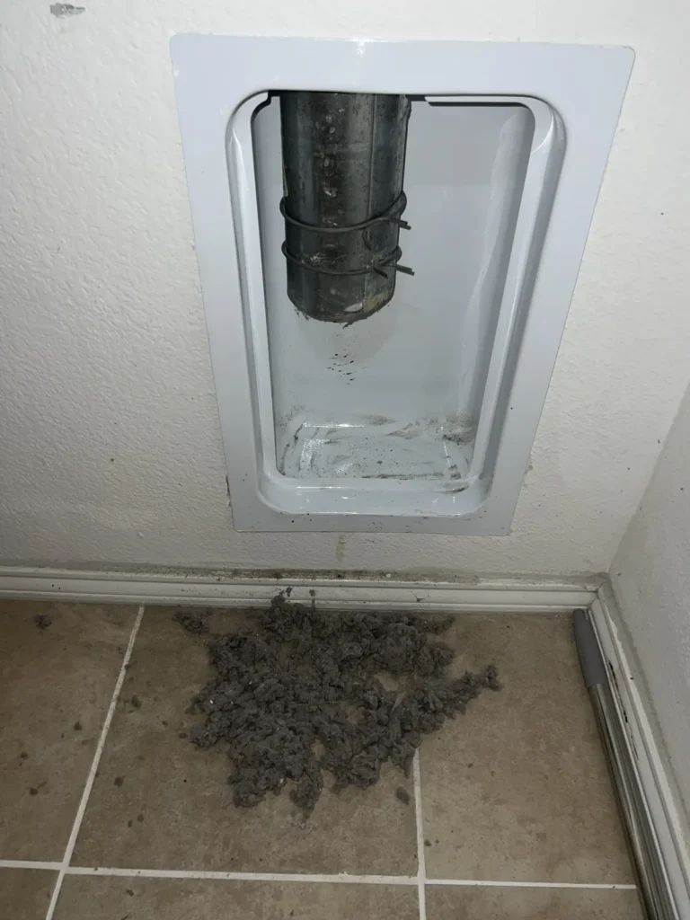 Dryer vent cleaning: recessed dryer vent box wiped clean with the lint pile removed below