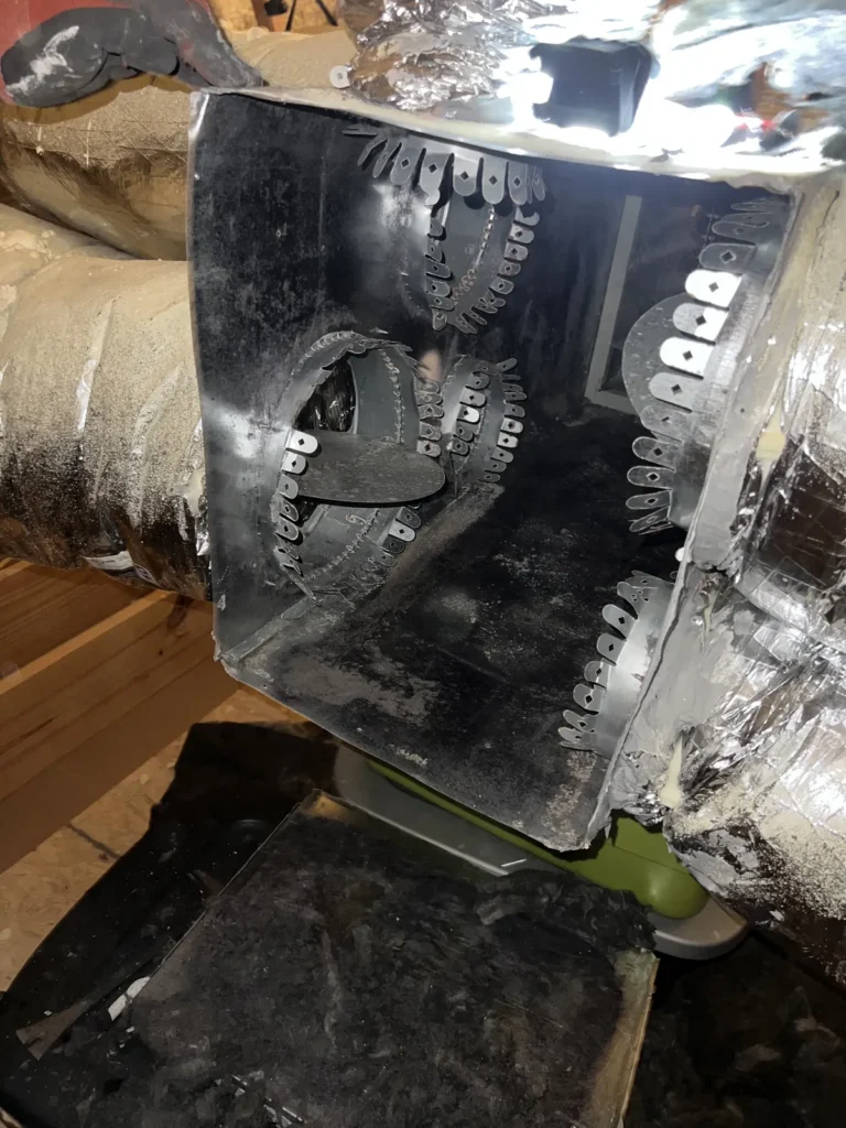 Plenum box repair: old sheet metal plenum opened up, showing cut collars and worn duct connections