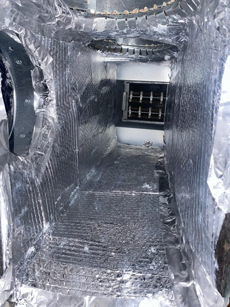 Plenum box repair: clean foil-lined plenum interior looking toward the air handler coil section