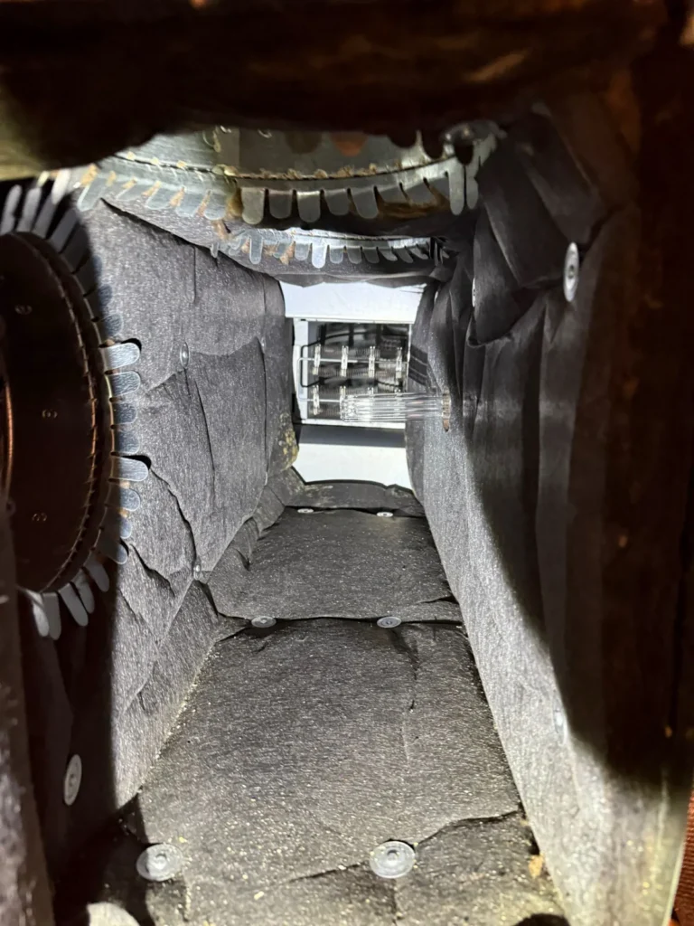 Plenum box repair: inside a worn plenum with aged duct board lining and metal takeoff collars