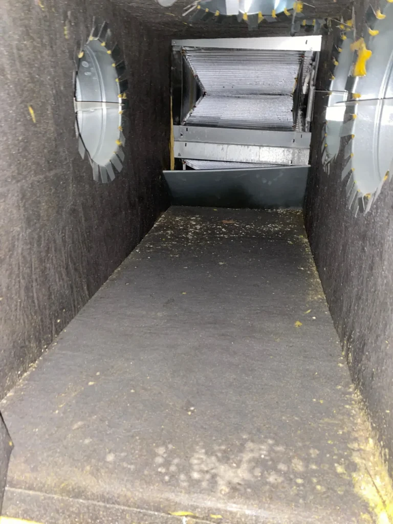 Plenum box repair: cleaned plenum interior showing evaporator coil and metal duct collars