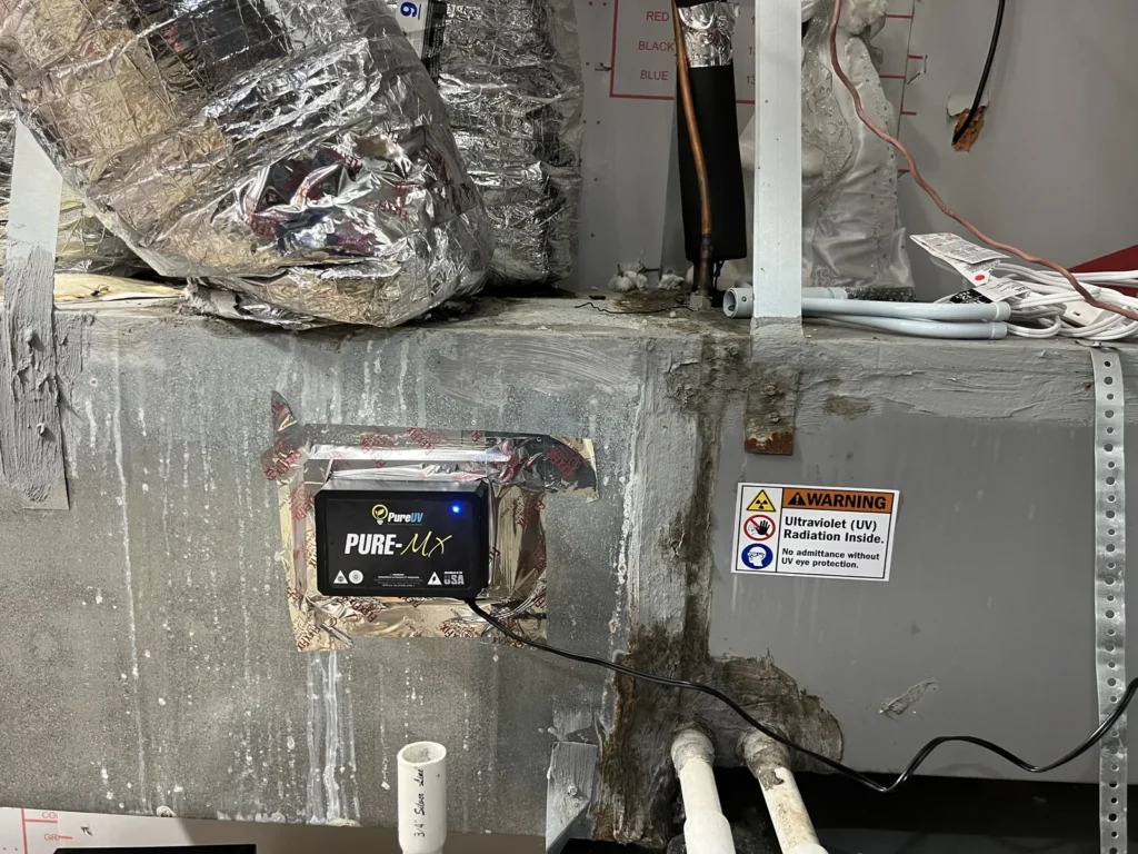 UV light installation: control unit and UV radiation warning label mounted on an air handler plenum