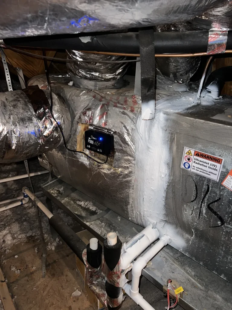 UV light installation: control box mounted on insulated attic ductwork near the air handler and drain lines