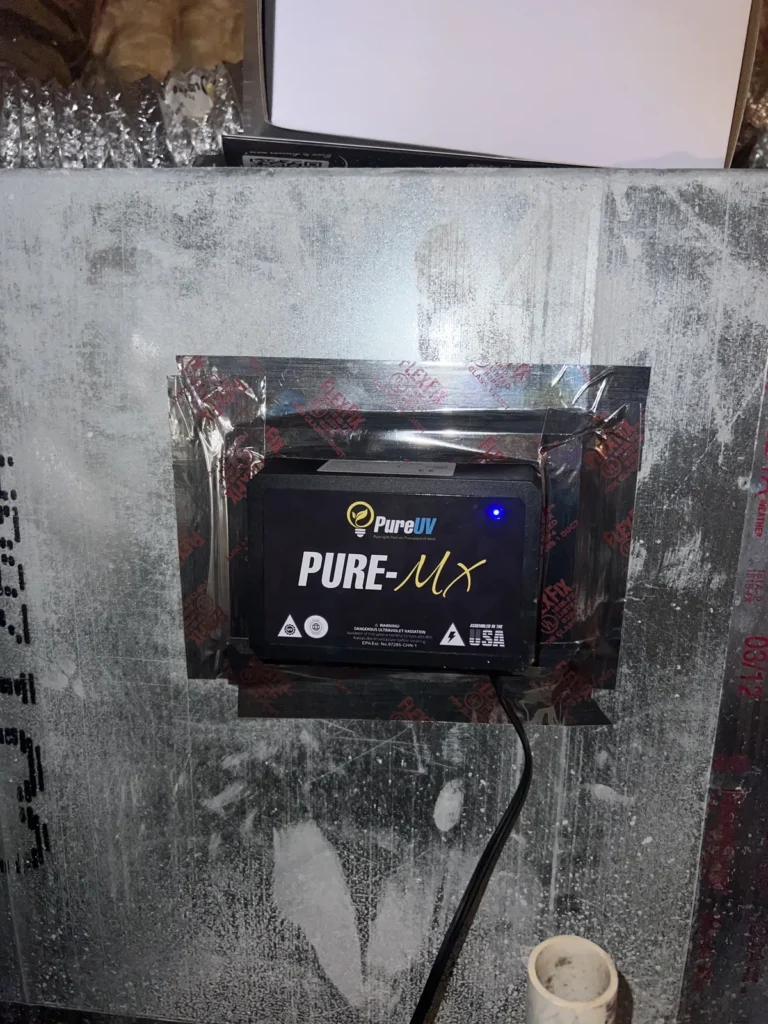UV light installation: Pure-MX purifier taped to a metal plenum with its blue power light lit