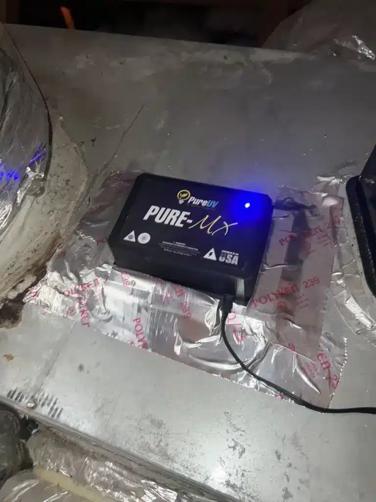 UV light unit glowing blue after installation on home HVAC ductwork