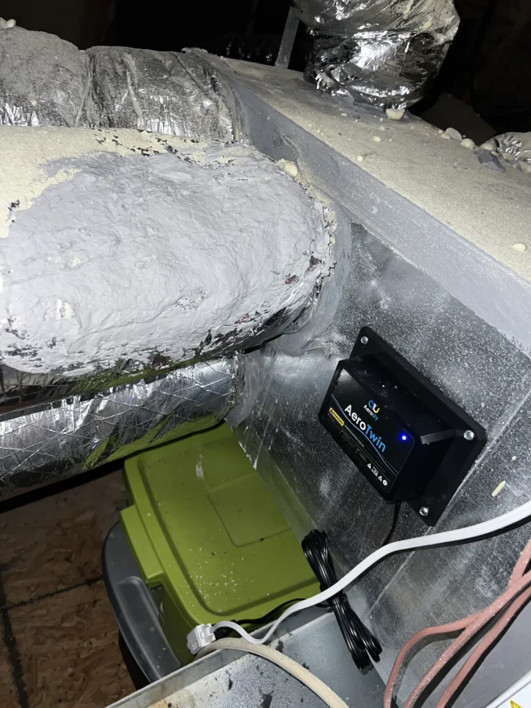 UV light installation: AeroTwin purifier mounted on a plenum beside an insulated duct in the attic