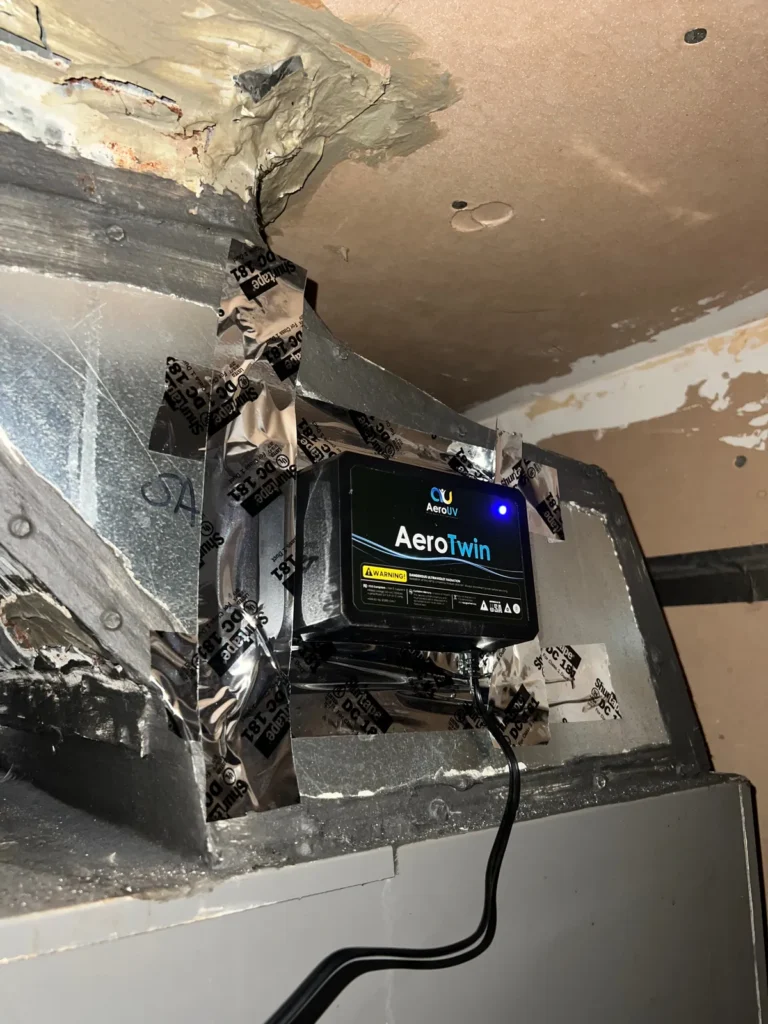 UV light installation: AeroTwin purifier secured with foil tape at a duct opening near the ceiling