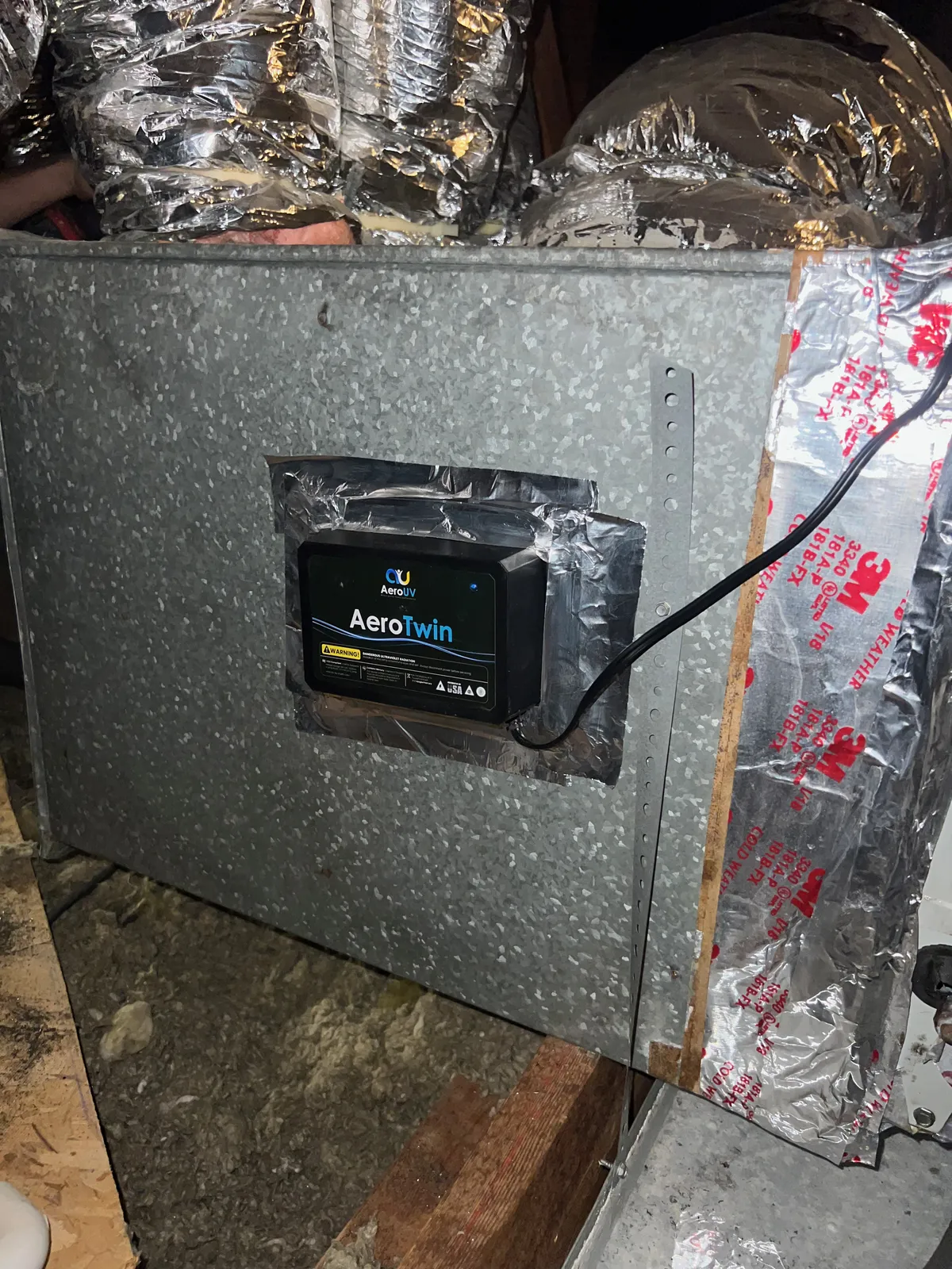 UV light installation: AeroTwin unit mounted on a galvanized plenum with foil tape and flex ducts behind